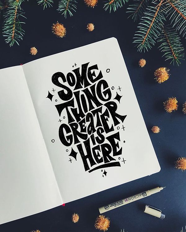 Something Greater Is Here — Ink lettering in a notebook